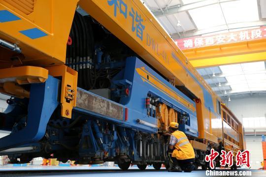 圖為工人正在清理大型養(yǎng)路機(jī)械。　張遠(yuǎn) 攝